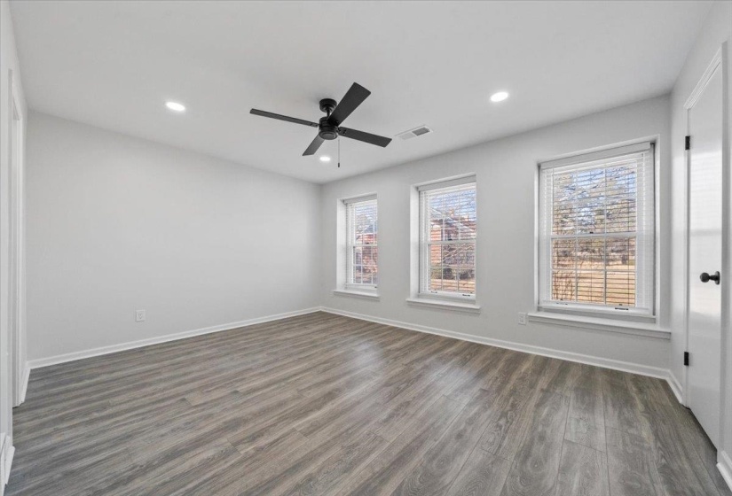 Spare room featuring dark wood-style flooring, recessed lighting, healthy amount of natural light, and a ceiling fan