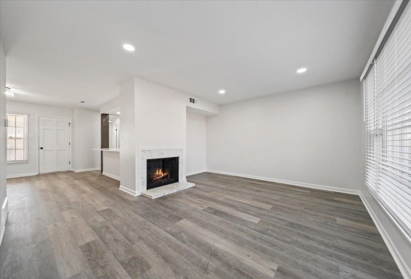Unfurnished living room featuring a fireplace, dark wood-type flooring, and recessed lighting