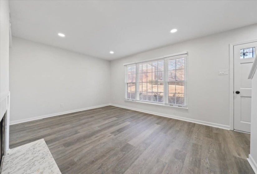 Unfurnished living room featuring wood finished floors and recessed lighting