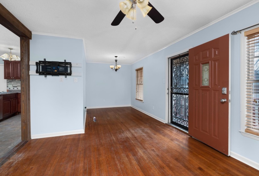Foyer featuring a chandelier, ornamental molding, dark wood finished floors, and a ceiling fan