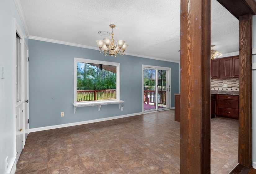 Unfurnished dining area with a chandelier, crown molding, and a textured ceiling