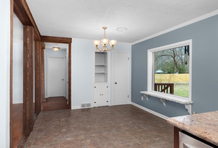 Unfurnished dining area with a chandelier, a textured ceiling, and crown molding