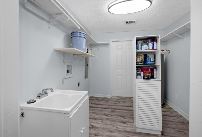 Washroom featuring hookup for a washing machine, a textured ceiling, light wood-type flooring, hookup for an electric dryer, and electric panel