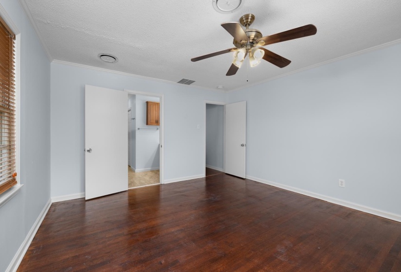 Unfurnished bedroom featuring a ceiling fan, hardwood / wood-style floors, a textured ceiling, and crown molding