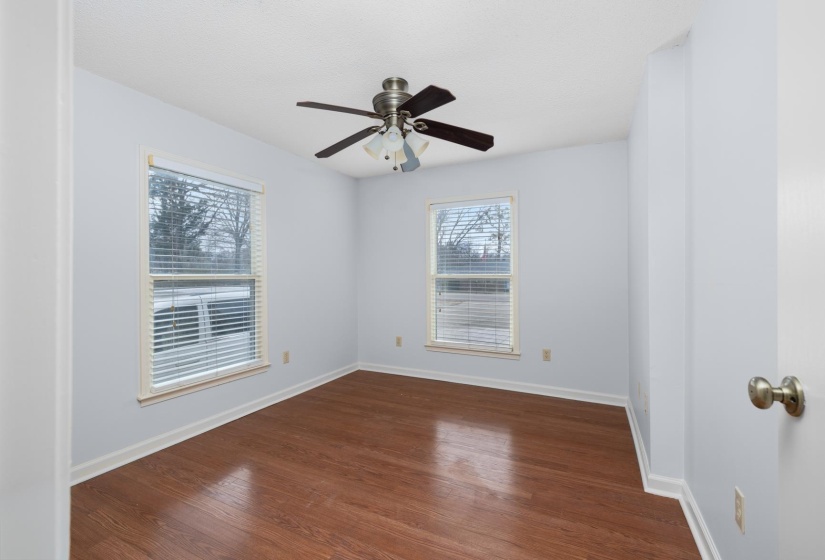 Unfurnished room featuring dark wood finished floors and a ceiling fan