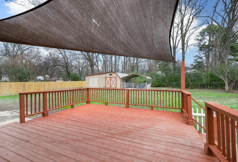 Deck featuring a fenced backyard and a storage shed