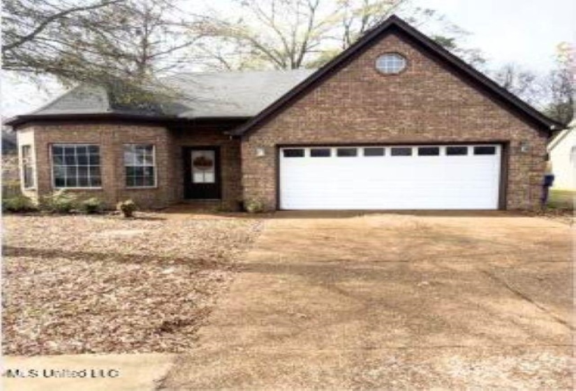 View of front facade with driveway and a garage