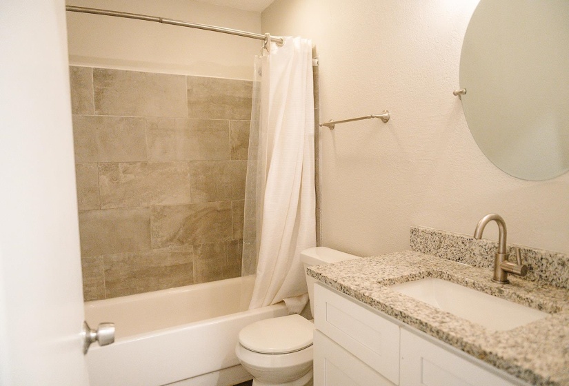Full bathroom with vanity, toilet, and shower / bath combo with shower curtain