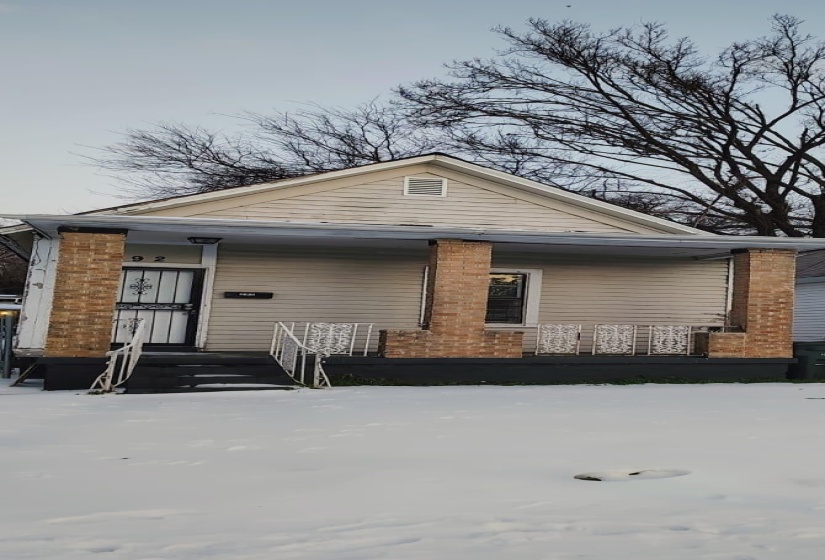 View of snow covered exterior with a deck and brick siding