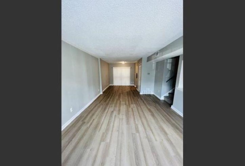 Unfurnished room with stairway, a textured ceiling, and light wood-style floors