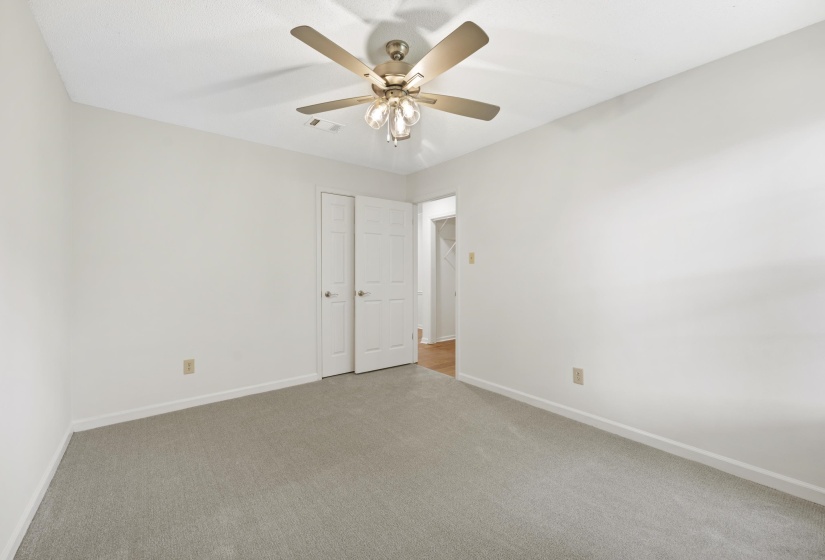 Empty room with carpet and a ceiling fan
