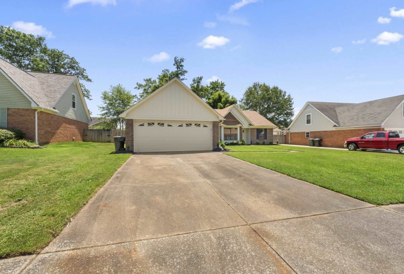 Ranch-style home featuring board and batten siding, brick siding, driveway, and a garage