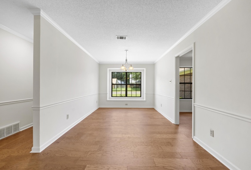 Unfurnished dining area with a chandelier, ornamental molding, and wood finished floors