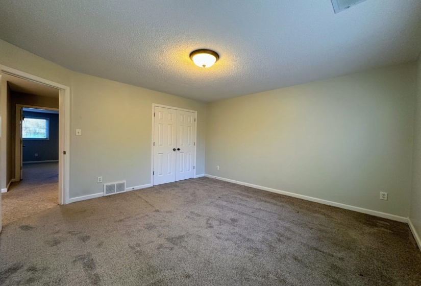 Unfurnished bedroom with carpet floors, a textured ceiling, and a closet