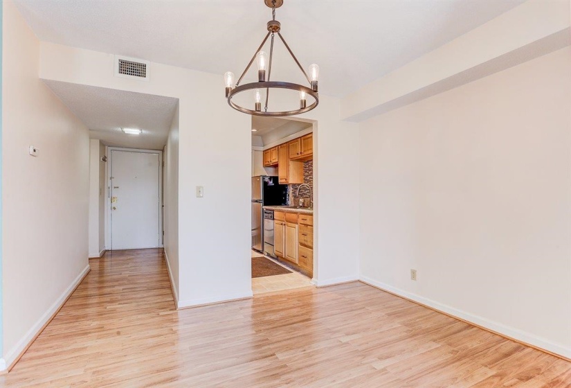 Unfurnished dining area with light wood-style flooring and a chandelier