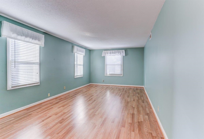 Empty room featuring wood finished floors and a textured ceiling