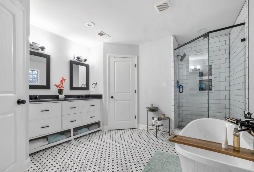 Bathroom with a shower stall, a soaking tub, double vanity, and light flooring