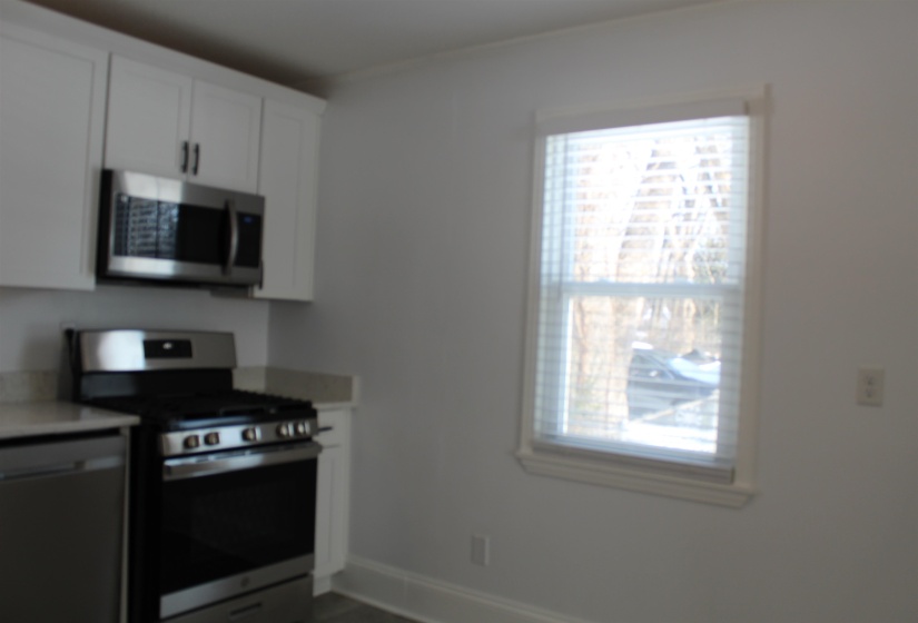 Kitchen featuring appliances with stainless steel finishes and white cabinetry