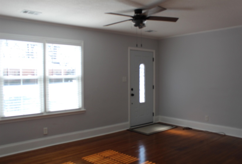 Entrance foyer with dark wood-style flooring, ceiling fan, and crown molding