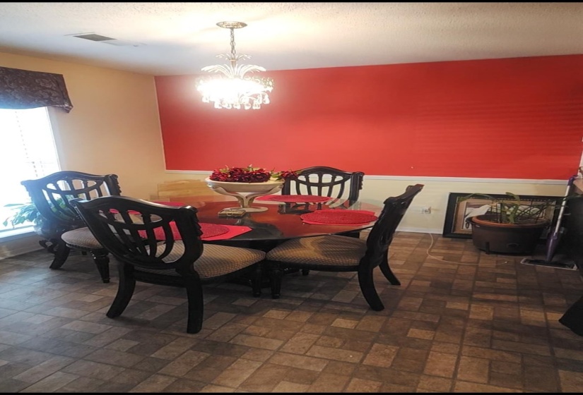 Dining space with a chandelier and brick patterned flooring