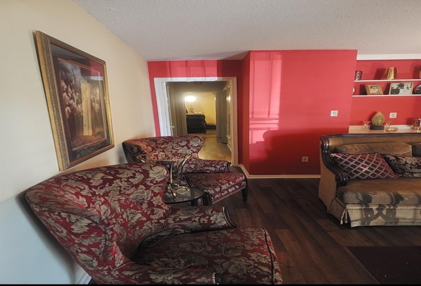 Bedroom with a textured ceiling and dark wood-style flooring