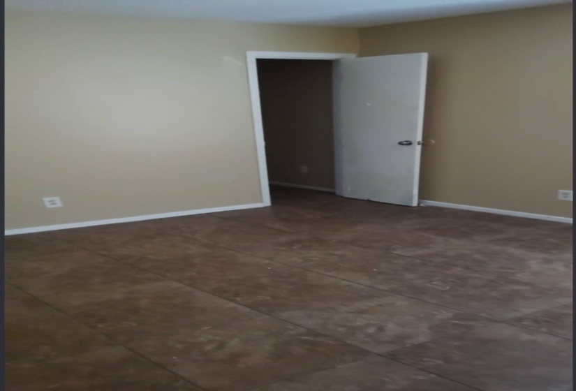 Empty room featuring baseboards and dark tile patterned floors