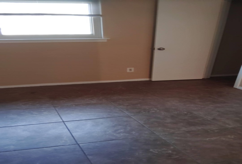 Empty room with baseboards and dark tile patterned floors