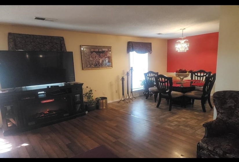 Living area with dark wood-style floors and a chandelier