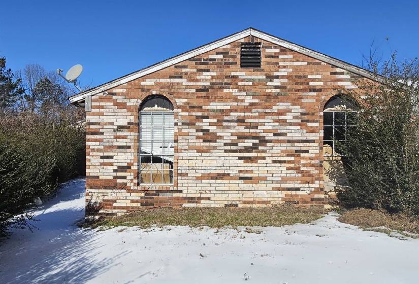 View of snow covered exterior featuring brick siding