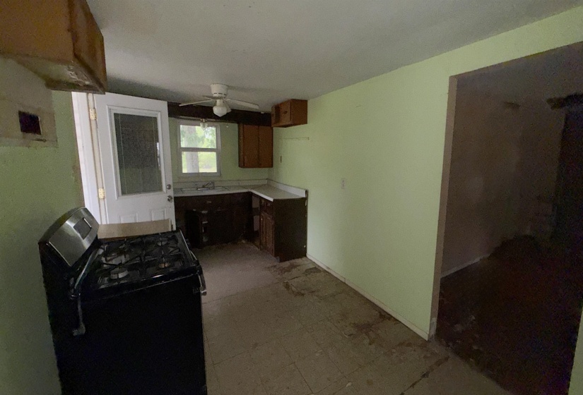 Kitchen area featuring a gas range, wood cabinetry, and a ceiling fan