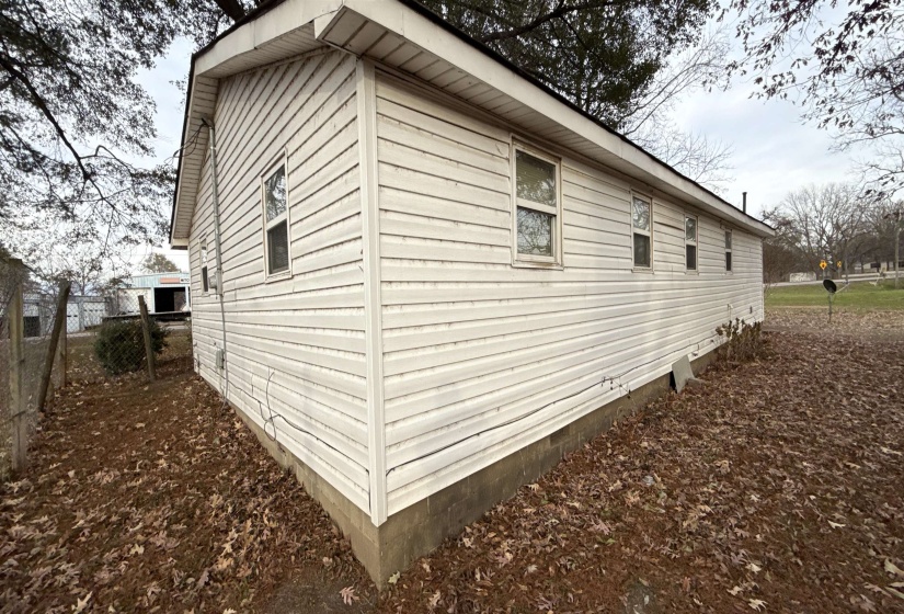 White vinyl siding exterior featuring multiple windows and a dark shingle roof
