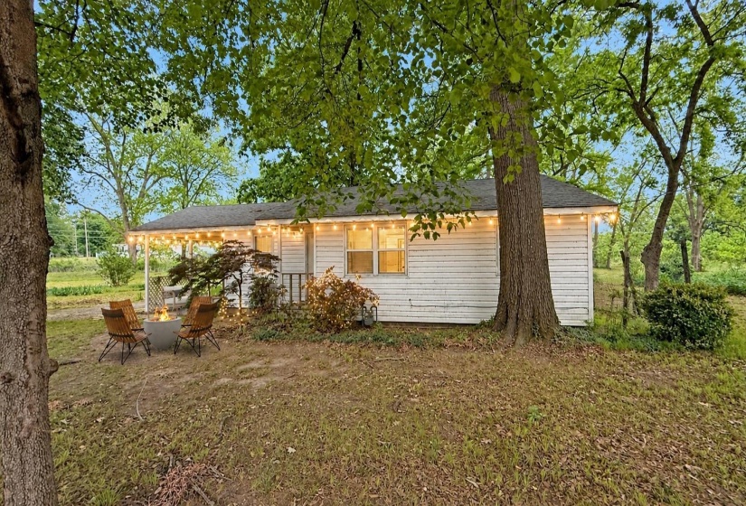 White siding exterior with a covered front porch and string lighting