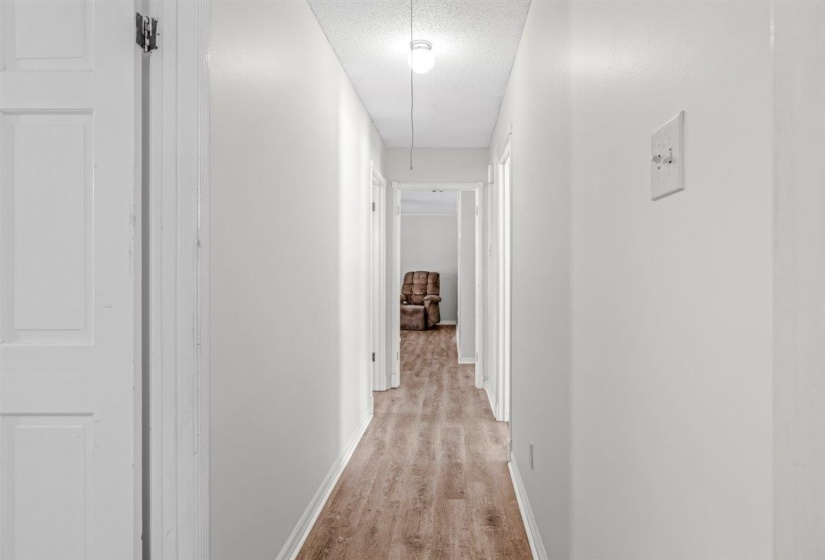 Living area with ornamental molding, wood finished floors, a ceiling fan, a fireplace, and plenty of natural light