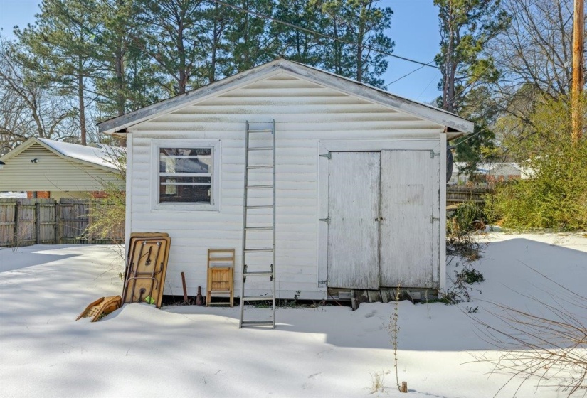 Snow covered structure with a storage shed