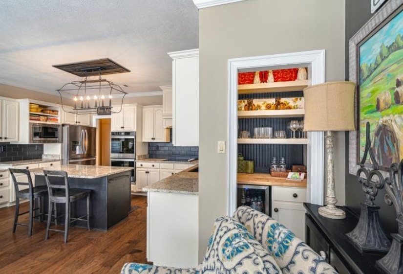 Kitchen featuring appliances with stainless steel finishes, a center island, a kitchen bar, and open shelves