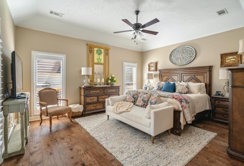 Bedroom featuring a ceiling fan, dark wood-style flooring, and visible vents