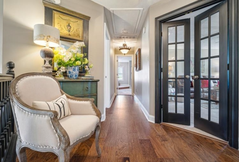 Corridor featuring dark wood-style flooring, french doors, visible vents, attic access, and baseboards