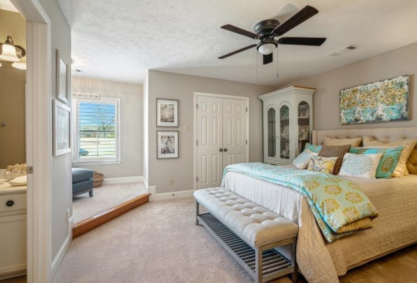 Bedroom featuring light carpet, baseboards, visible vents, a textured ceiling, and a closet