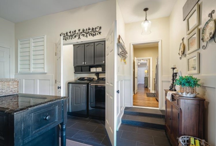 Interior space with dark tile patterned flooring and washing machine and dryer