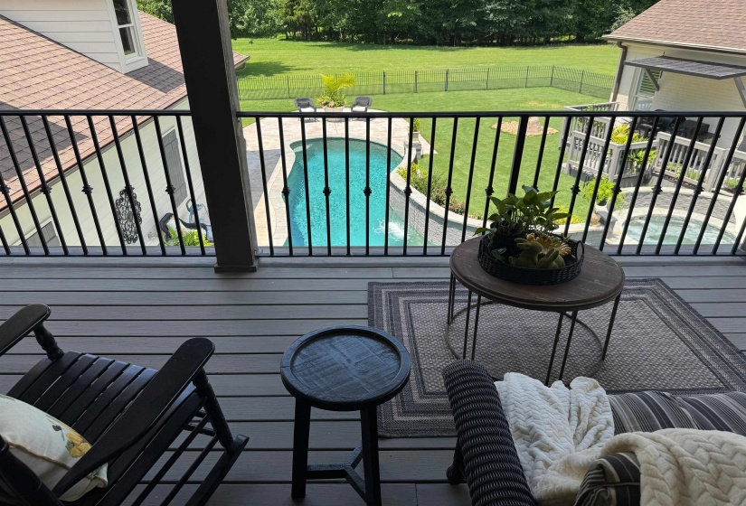 Wooden deck with a fenced backyard and a patio area