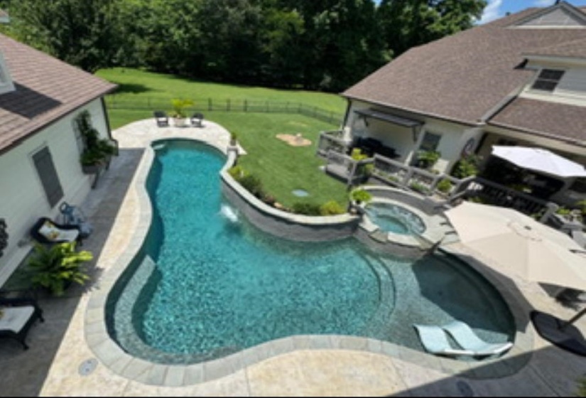 View of swimming pool featuring a fenced backyard, a patio area, and a pool with connected hot tub