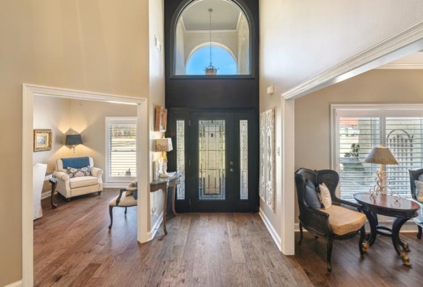 Entryway featuring wood finished floors, a wealth of natural light, and baseboards - the office is to left in photo and living room to the right