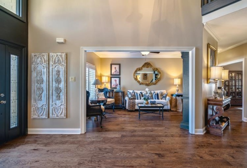 Entrance foyer featuring dark wood-style floors, ornamental molding, a towering ceiling, and baseboards