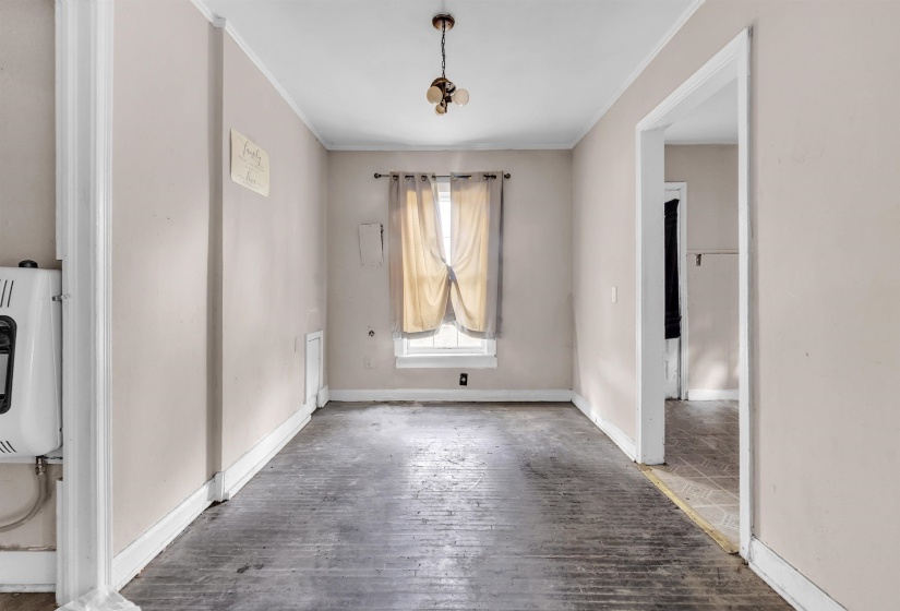 Unfurnished dining area featuring hardwood / wood-style flooring, heating unit, and crown molding