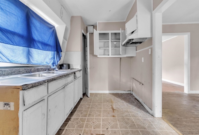 Kitchen featuring white cabinets, light countertops, and crown molding