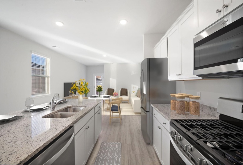 Kitchen with appliances with stainless steel finishes, white cabinetry, light stone counters, light wood-style floors, and recessed lighting