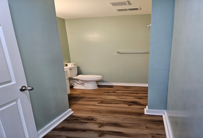 Bathroom with baseboards and dark wood-type flooring