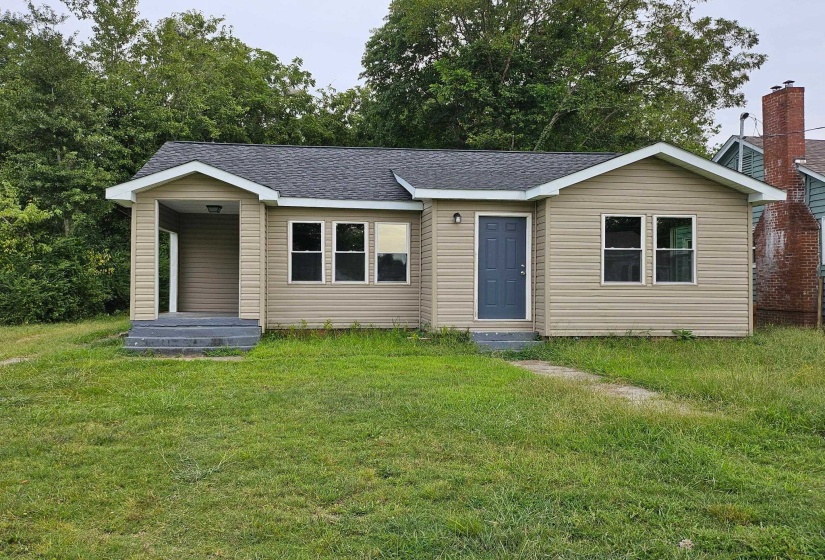 View of front facade featuring roof with shingles and a front lawn