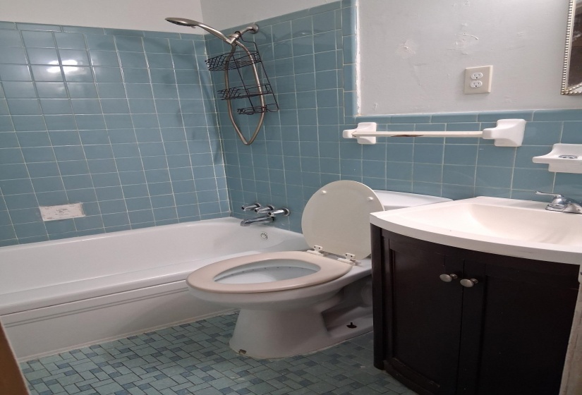 Bathroom with shower / bath combination, vanity, tile walls, tile patterned flooring, and wainscoting