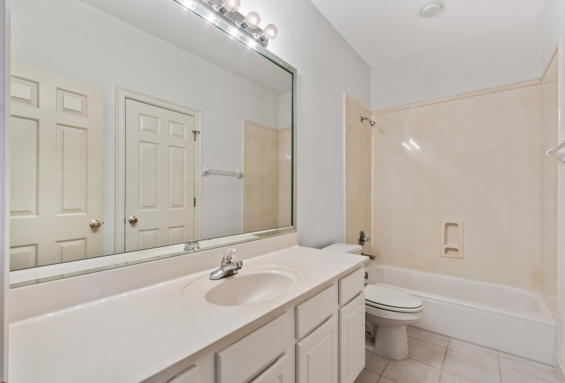 Bathroom featuring a vanity with integrated sink, chrome faucet, and storage cabinetry